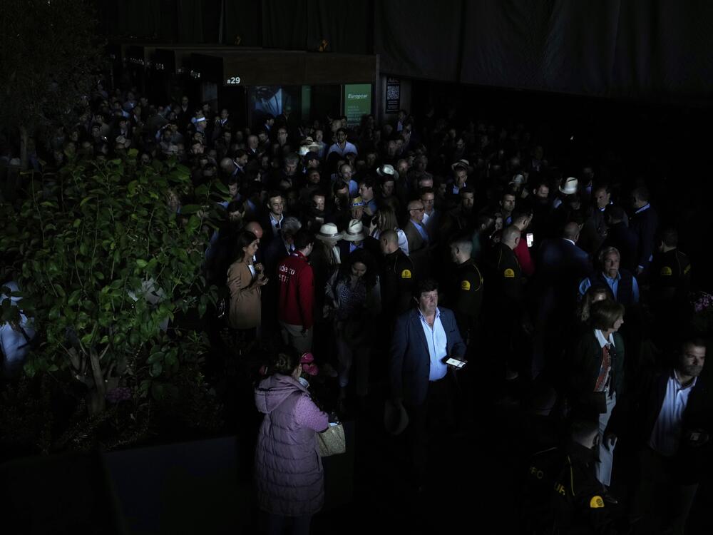 Spectators roam inside the Madrid Open tennis tournament venue during a general blackout in Madrid on April 28.