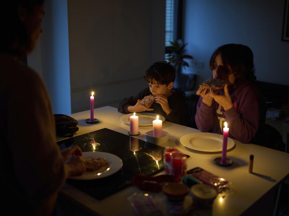 A family eats a snack by candlelight during a blackout in Barcelona, Spain on April 28.