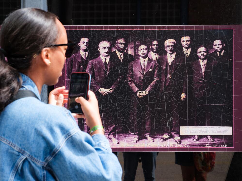 An attendee takes a picture of the North Carolina Mutual Life Insurance founders, the largest Black-owned insurance company, during a walking tour of Durham's Black Wall Street.