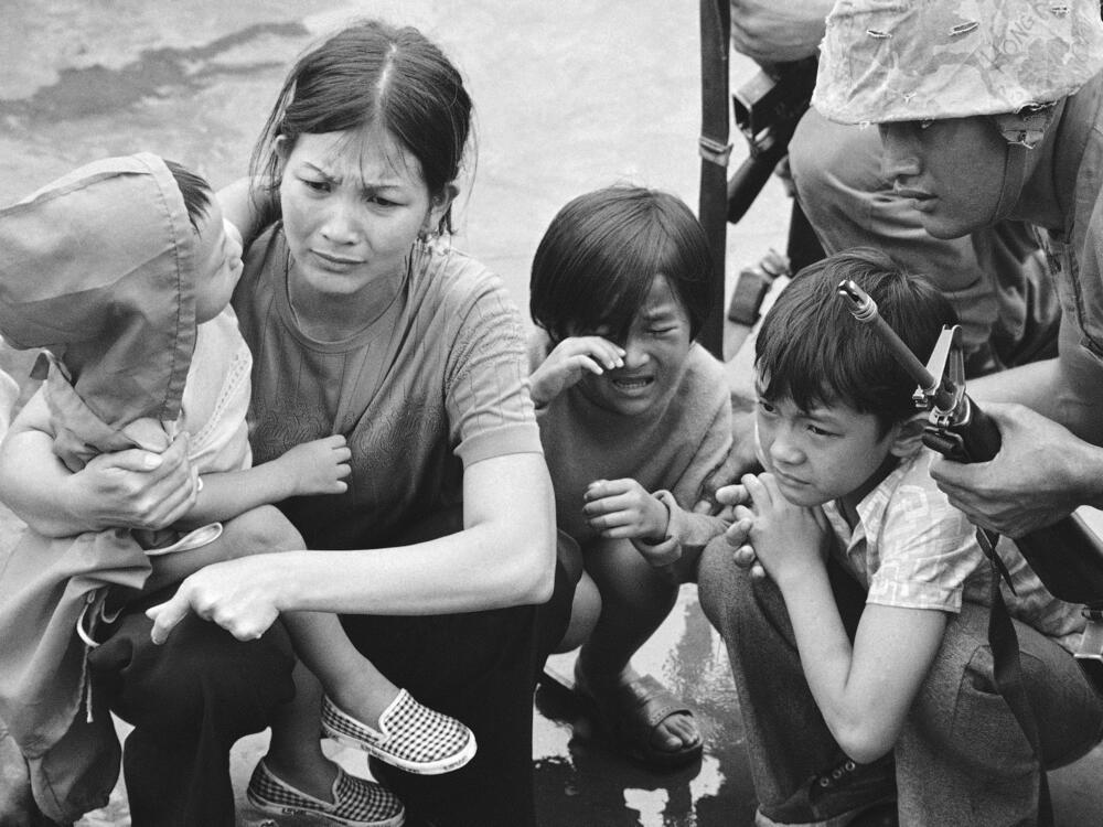 A South Vietnamese mother and her three children on the deck of an amphibious command ship being plucked out of Saigon by U.S. Marine helicopters on April 29, 1975.