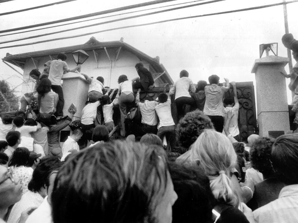 South Vietnamese civilians try to scale the walls of the U.S. Embassy in Saigon in an attempt to get aboard evacuation flights on April 30, 1975.