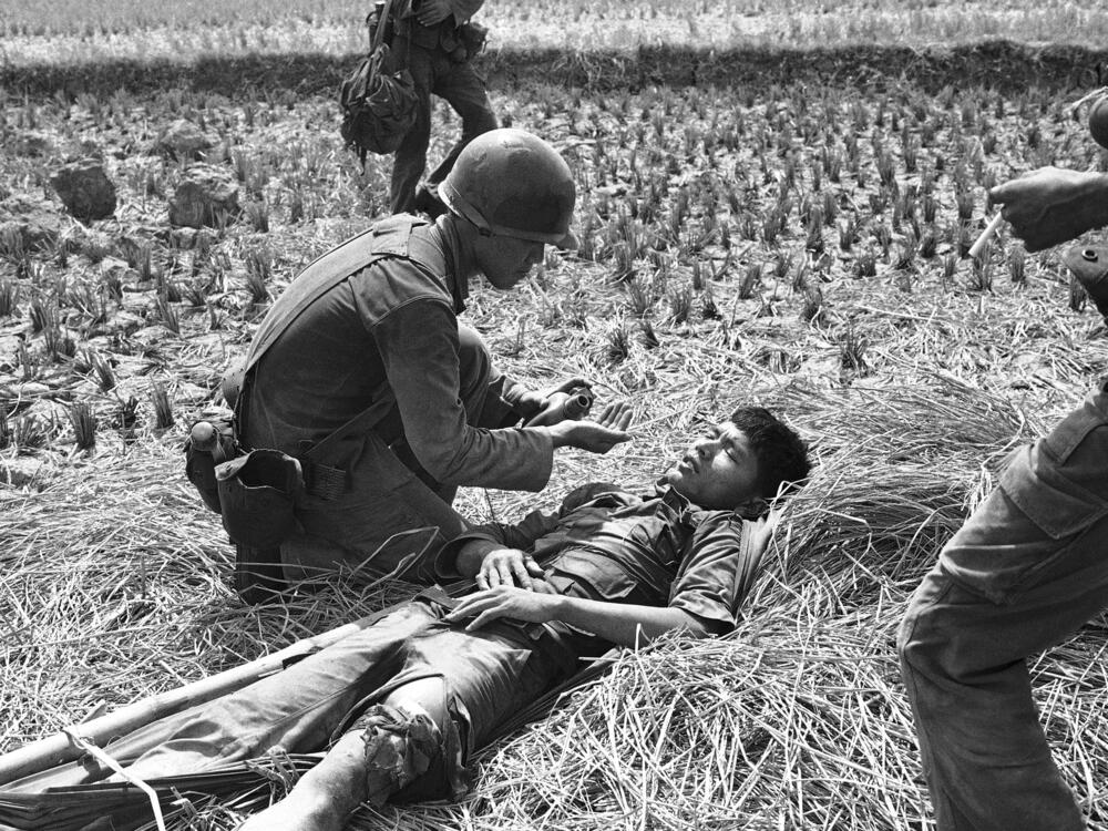 A South Vietnamese medic comforts a trooper wounded in the leg during a battle in Long An province, southwest of Saigon, on April 18, 1975.