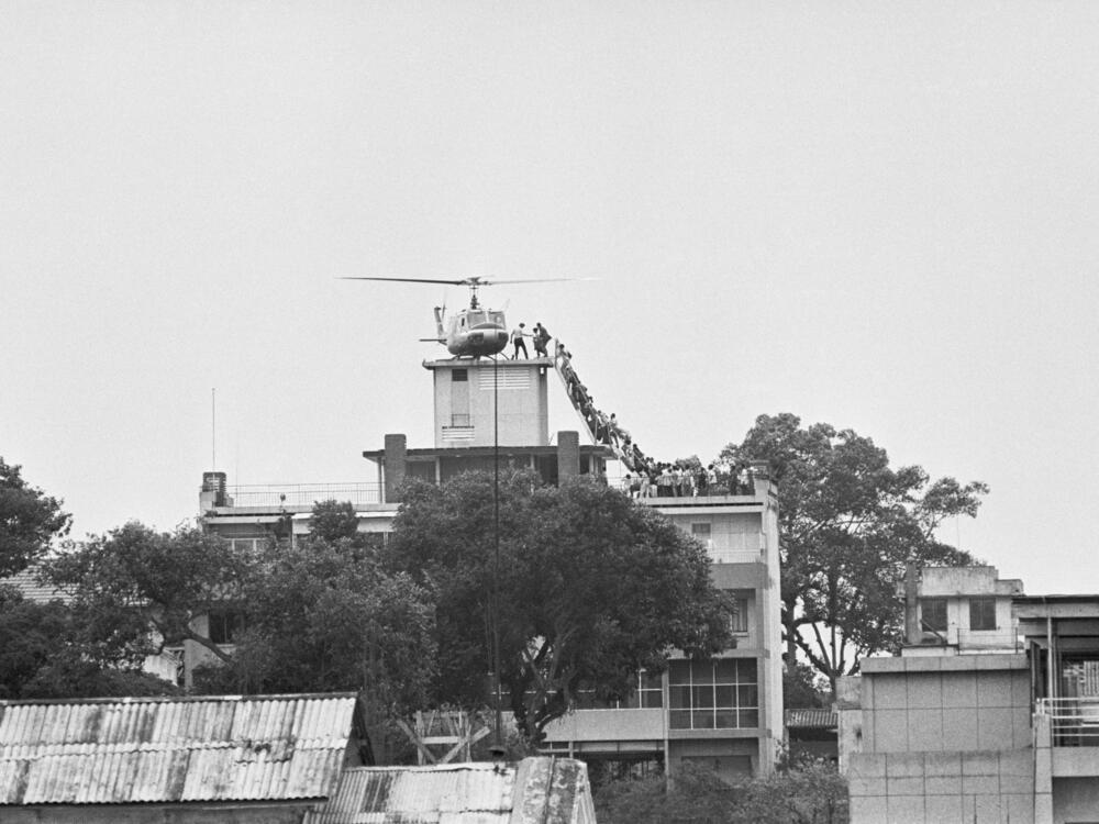 A CIA employee helps Vietnamese evacuees onto an Air America helicopter from the top of 22 Gia Long St., a half mile from the U.S. Embassy.