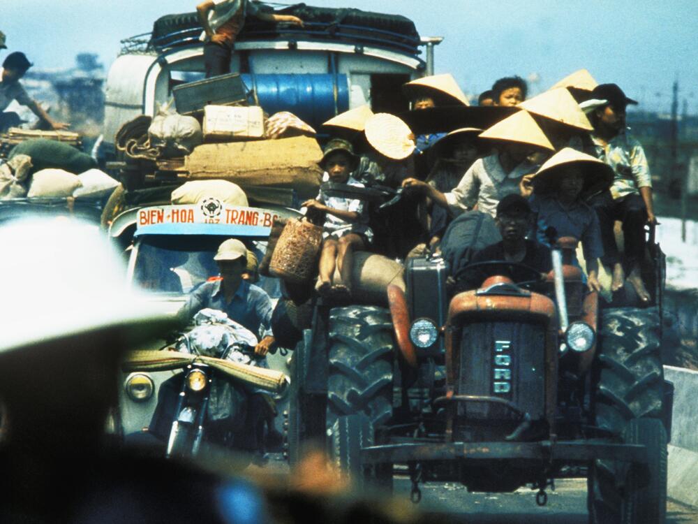 Desperate South Vietnamese refugees cling to vehicles along Highway 1 as they flee North Vietnamese troops advancing to capture Saigon a few days before the fall of Saigon that signaled the end of the Vietnam War.