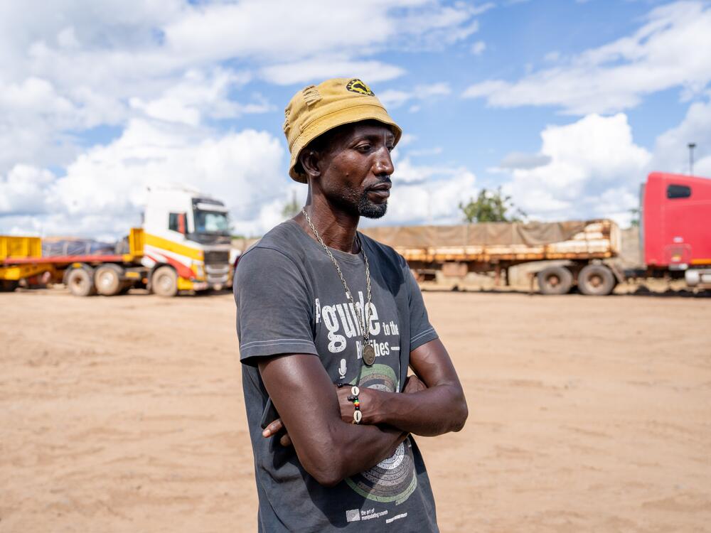 Zambian trucker Roi Silunyange, 54, stands in a parking lot at a truck stop near the border with the Democratic Republic of Congo. He says that he knows a fellow truck driver who died while in Congo because he ran out of HIV medication.