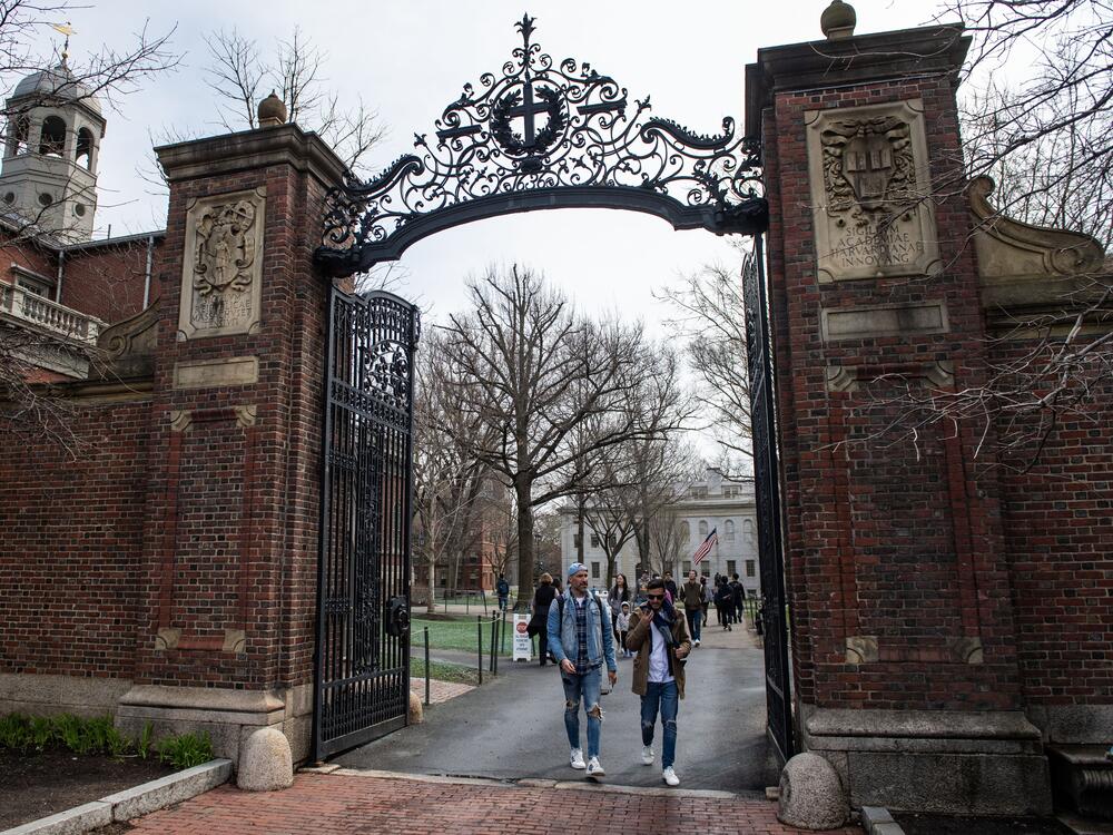 People walk through a gate as they exit Harvard Yard on the campus of Harvard University in Cambridge, Mass., on April 15. The Trump administration has sent a series of sweeping demands to Harvard University, including an end to diversity programs, audits to ensure 