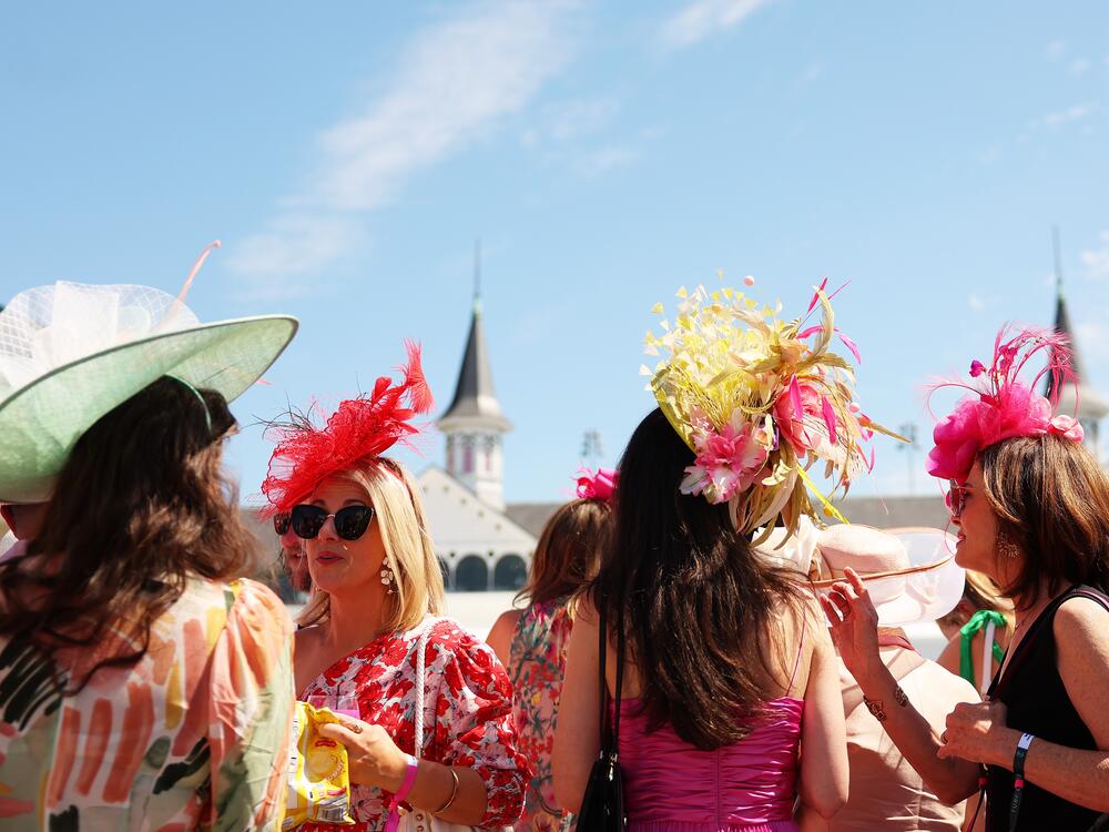 Spectators wearing festive hats look on in the paddock ahead of the 149th running of the Kentucky Derby at Churchill Downs on May 5, 2023.
