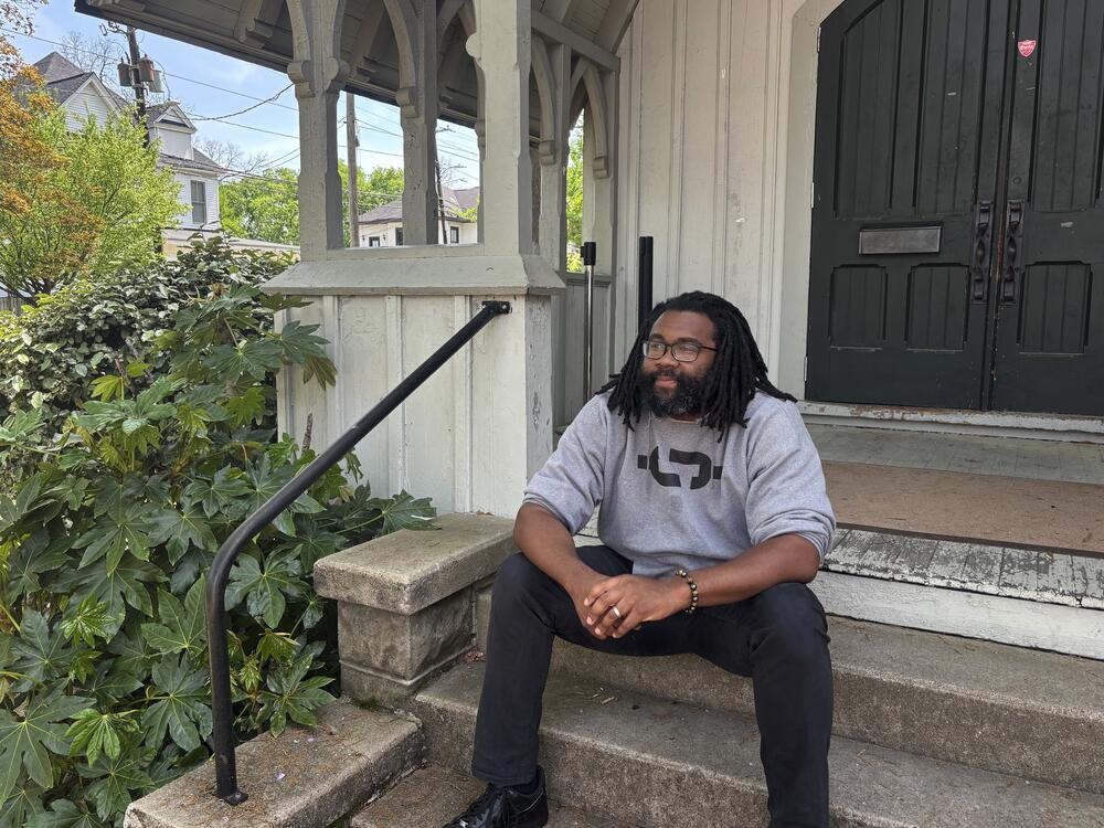 Evan Milligan, the named plaintiff in the redistricting lawsuit, sits on the porch of a community center he runs in a former church near downtown Montgomery.