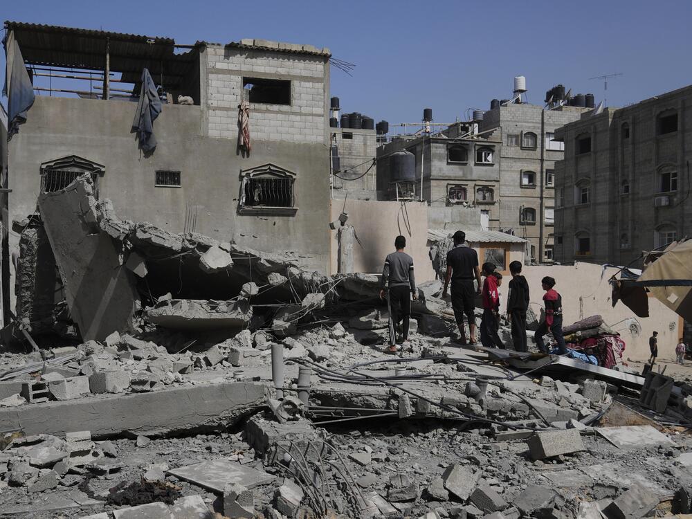 Palestinians look at a house targeted by an Israeli army strike in Khan Younis, Gaza Strip, Saturday, May 3, 2025.