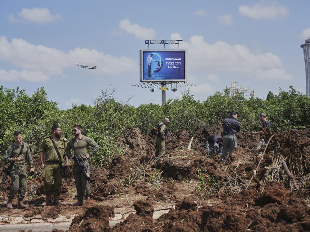 Israeli security forces inspect the site where the Israeli military said a projectile fired by Yemen's Houthi rebels landed in the area of Ben Gurion International Airport near Tel Aviv, Israel, on Sunday, May 4, 2025.