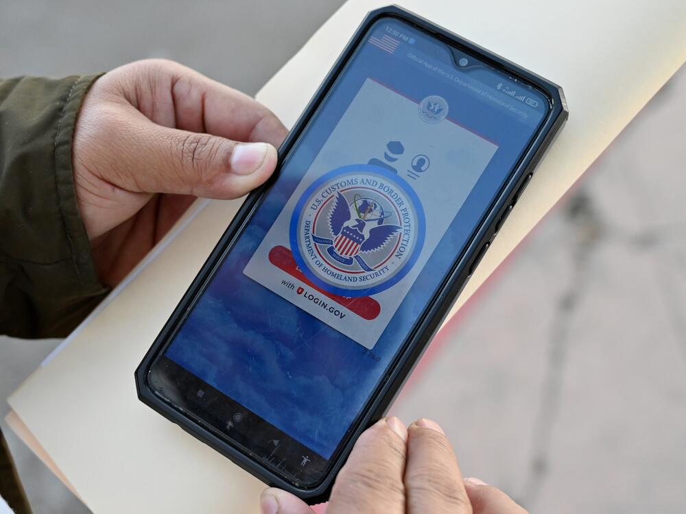 An asylum seeker with a canceled appointment to enter the United States waits to speak to a Mexican immigration official as he reviews the CBP One app at the El Chaparral border crossing port in Tijuana, Mexico, in January 2025.