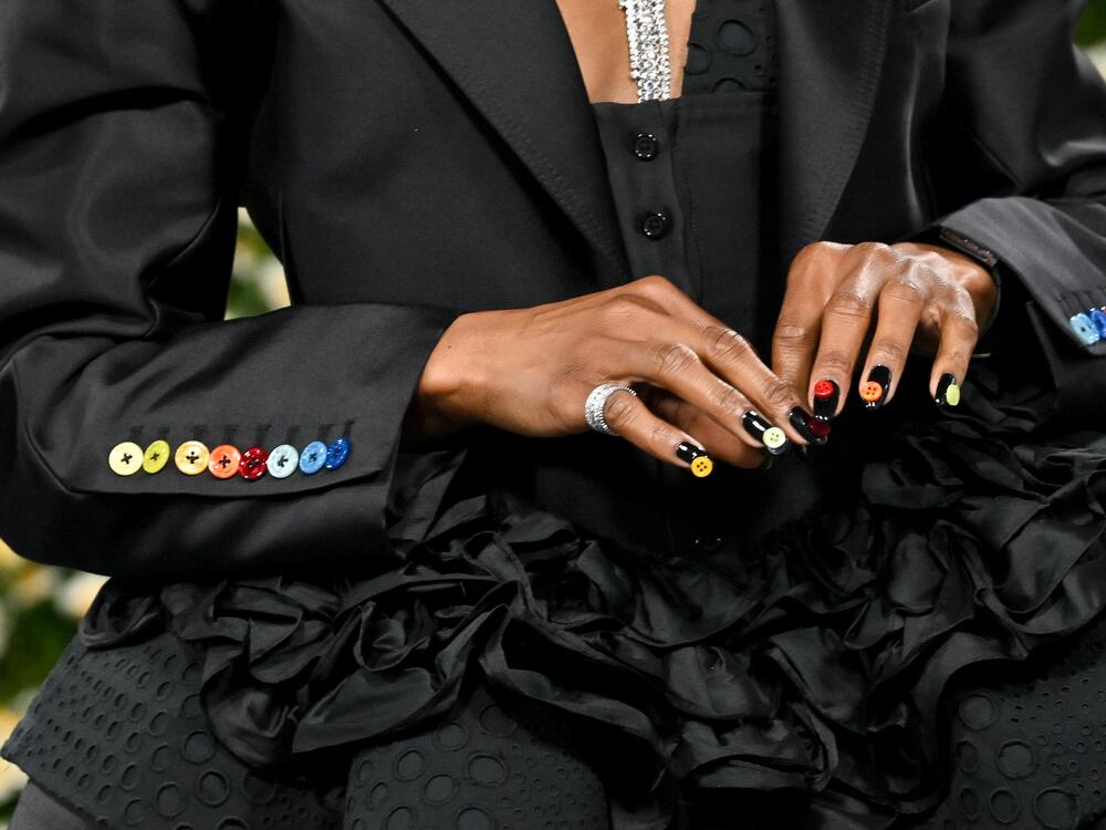 A detail of Ego Nwodim's outfit, including fingernails adorned with colorful buttons, at the 2025 Met Gala.