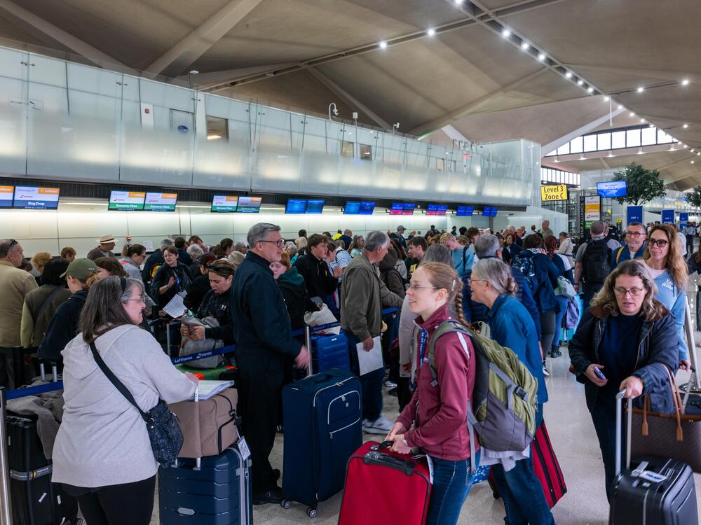 People wait in line for a delayed flight at Newark International Airport on Monday in Newark, N.J. Delays and cancellations at one of the nation's busiest airports have persisted for several days.