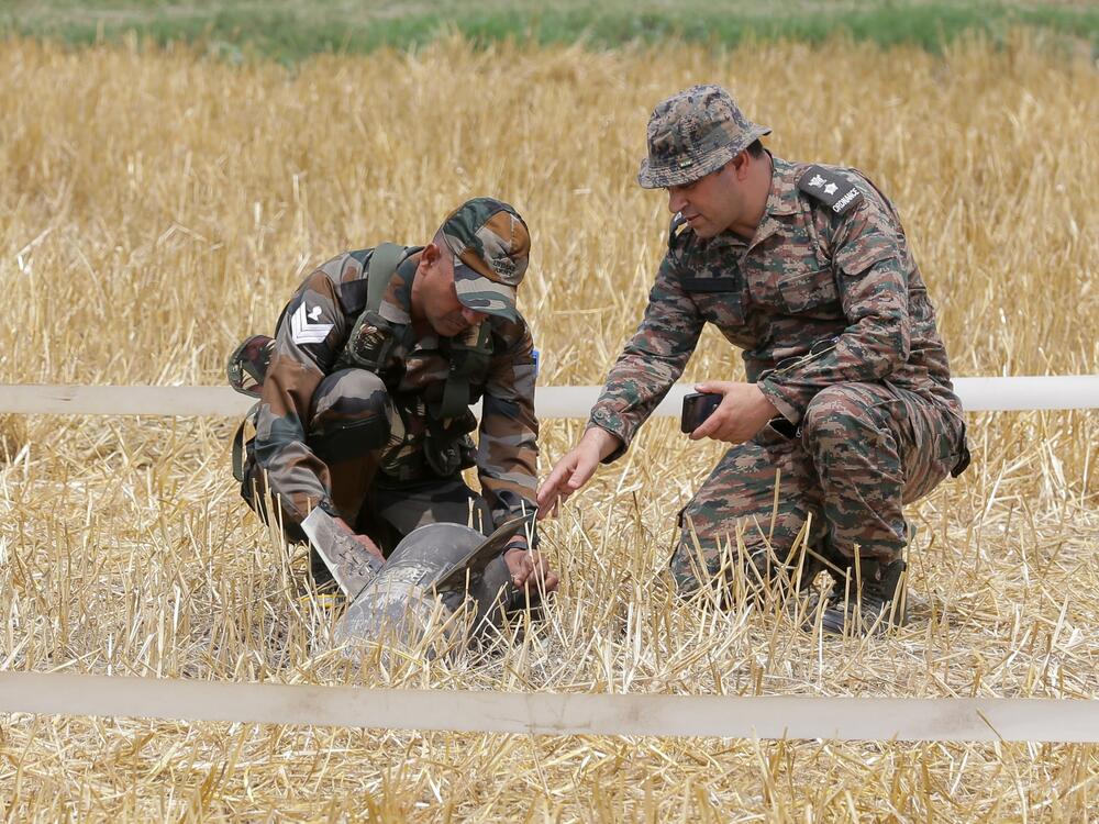 Army personnel examine the remains of a projectile discovered in Makhanwindi village near Amritsar, India, on Thursday.