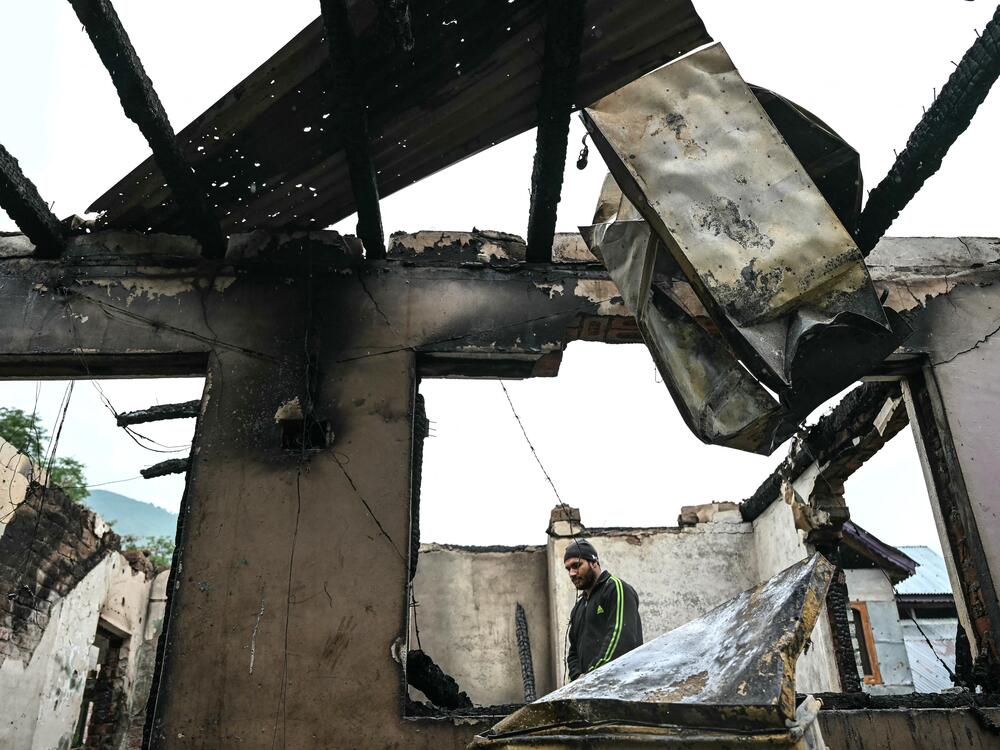 A man stands inside his house destroyed by Pakistani artillery shelling in the village of Salamabad, India, Thursday.