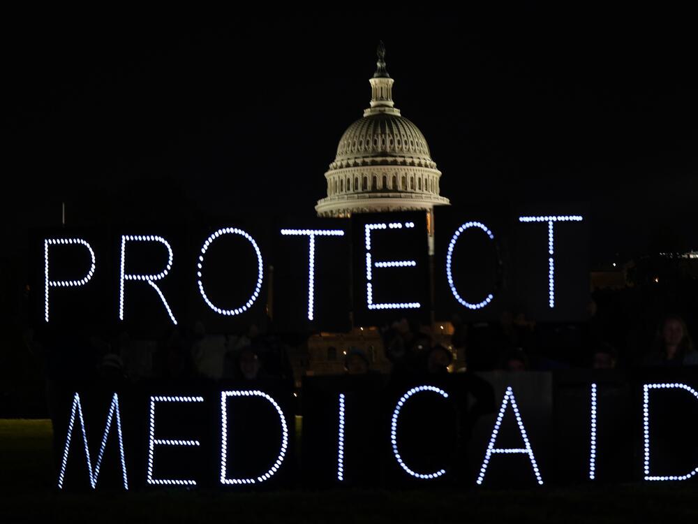 Protect Medicaid signs light up at a demonstration outside the Capitol on Wednesday.