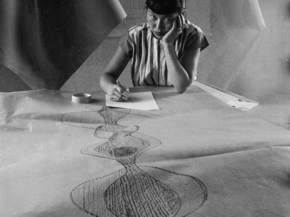 Portrait of Japanese American sculptor Ruth Asawa as she sketches a design, November 1954.