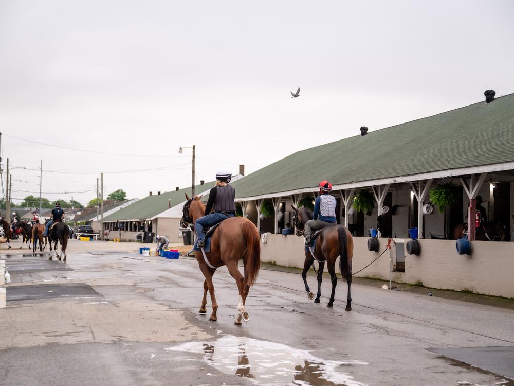 Riders on horseback travel through the backside of Churchill Downs in Louisville, Ky., on April 30, 2025.