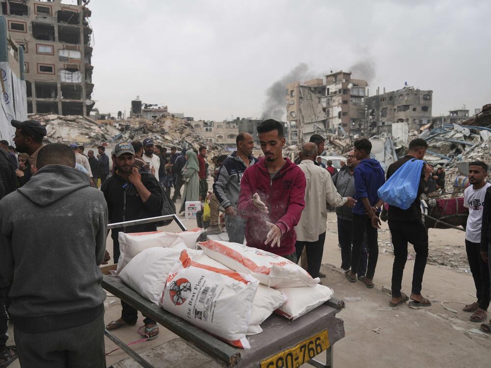 Palestinians receive bags of flour and other humanitarian aid distributed by UNRWA, the U.N. agency helping Palestinian refugees in Jabaliya, Gaza Strip on Tuesday, April 1, 2025.