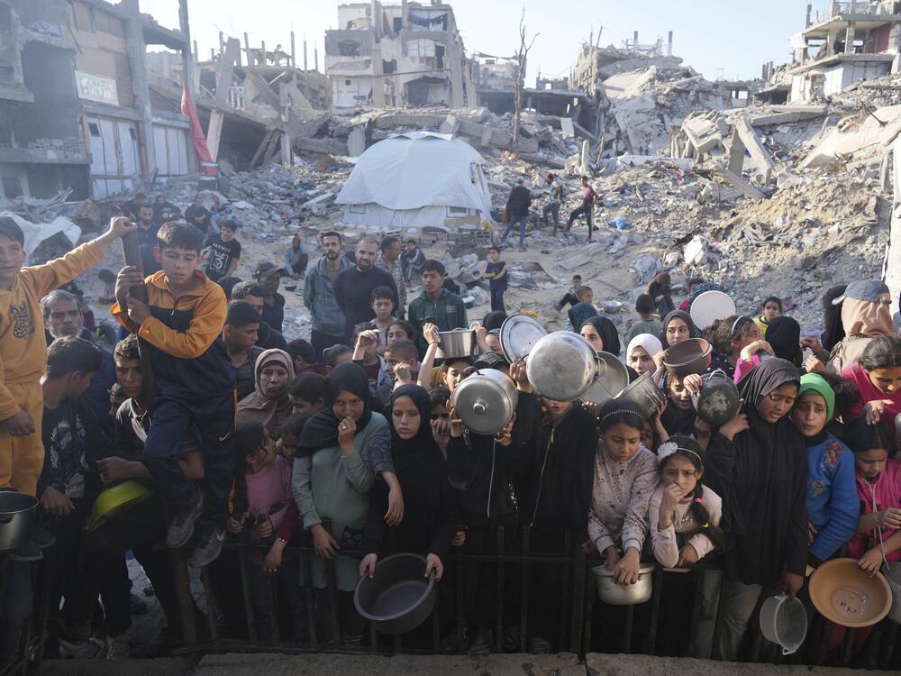 Palestinians wait for donated food at a distribution center in Beit Lahiya, northern Gaza Strip, Sunday, March 16, 2025.