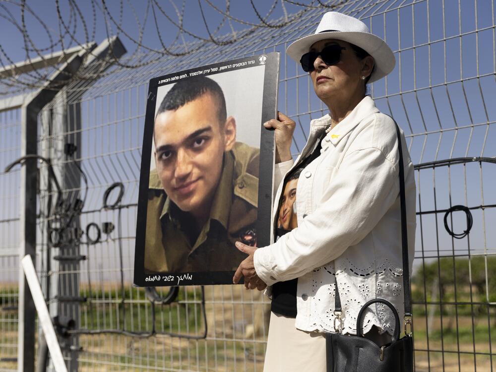 Varda Ben Baruch holds a photo of her grandson Israeli American hostage Edan Alexander during a rally of families of hostages held in the Gaza Strip on April 20 in Nir Oz, Israel.