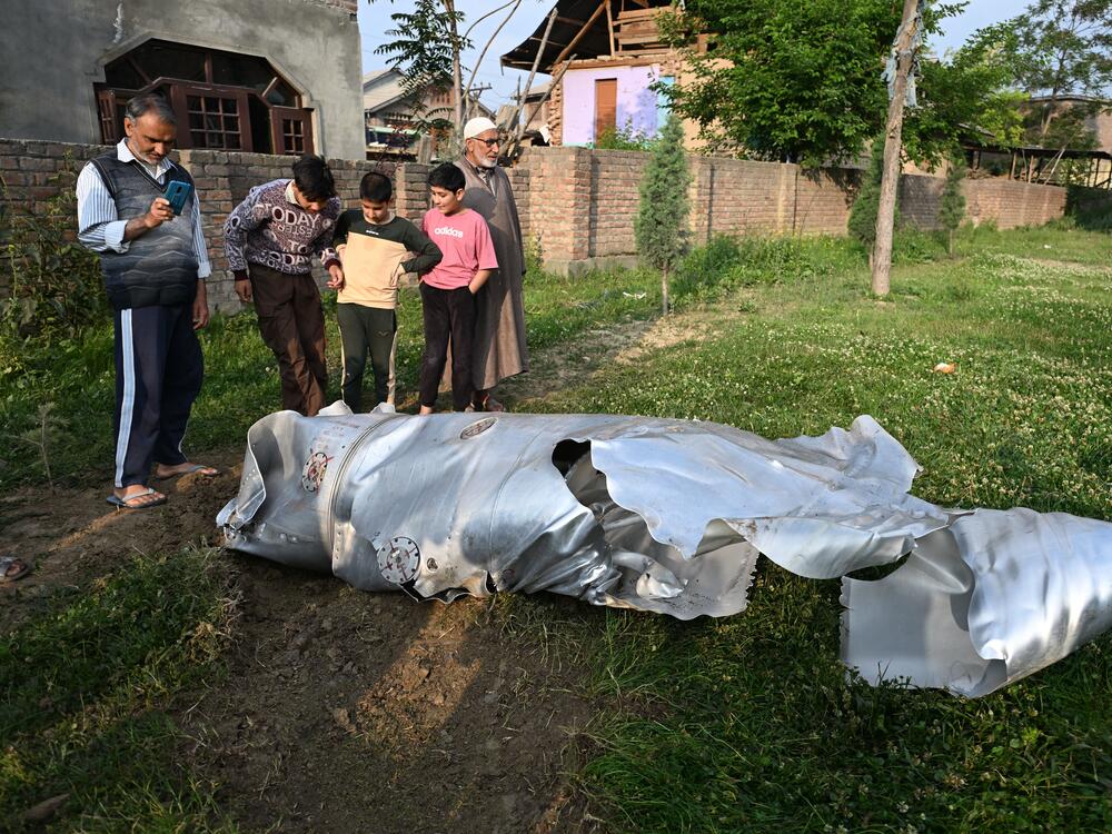 People look at the debris of an aircraft in Wuyan, a village in the Pulwama district in Indian-administered Kashmir, May 7.
