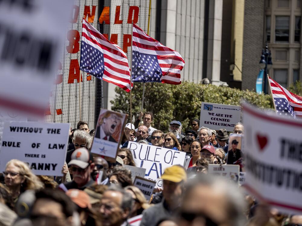 Attendees hold inverted U.S. flags, a sign of distress,  during a rally organized by the Bar Association of San Francisco in support of attorneys and law firms targeted by President Donald Trump on May 1.