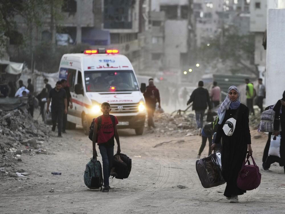 Palestinians evacuate after the Israeli army issued an evacuation warning for several schools and a hospital in Gaza City's Rimal neighborhood, Wednesday, May 14, 2025.