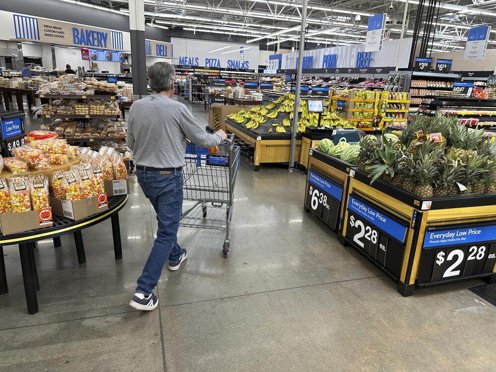 Shopper pushes a basket into the produce section of a Walmart store in Englewood, Colo.