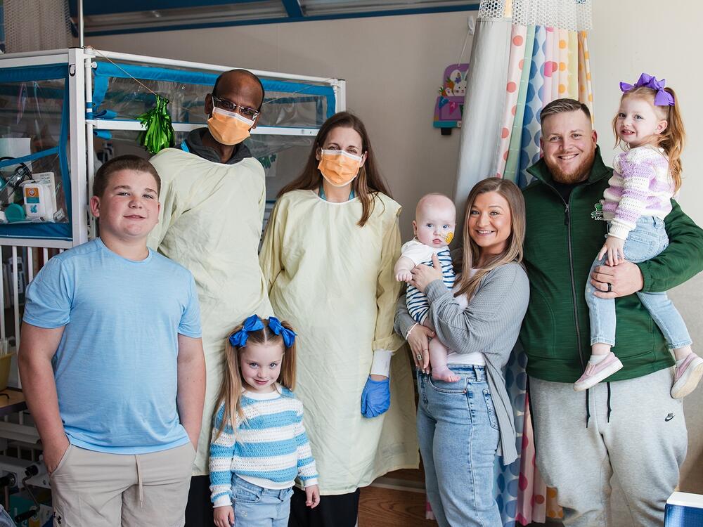 Dr. Kiran Musunuru and Dr. Rebecca Ahrens-Nicklas pose for a portrait with KJ and his family after an infusion treatment.
