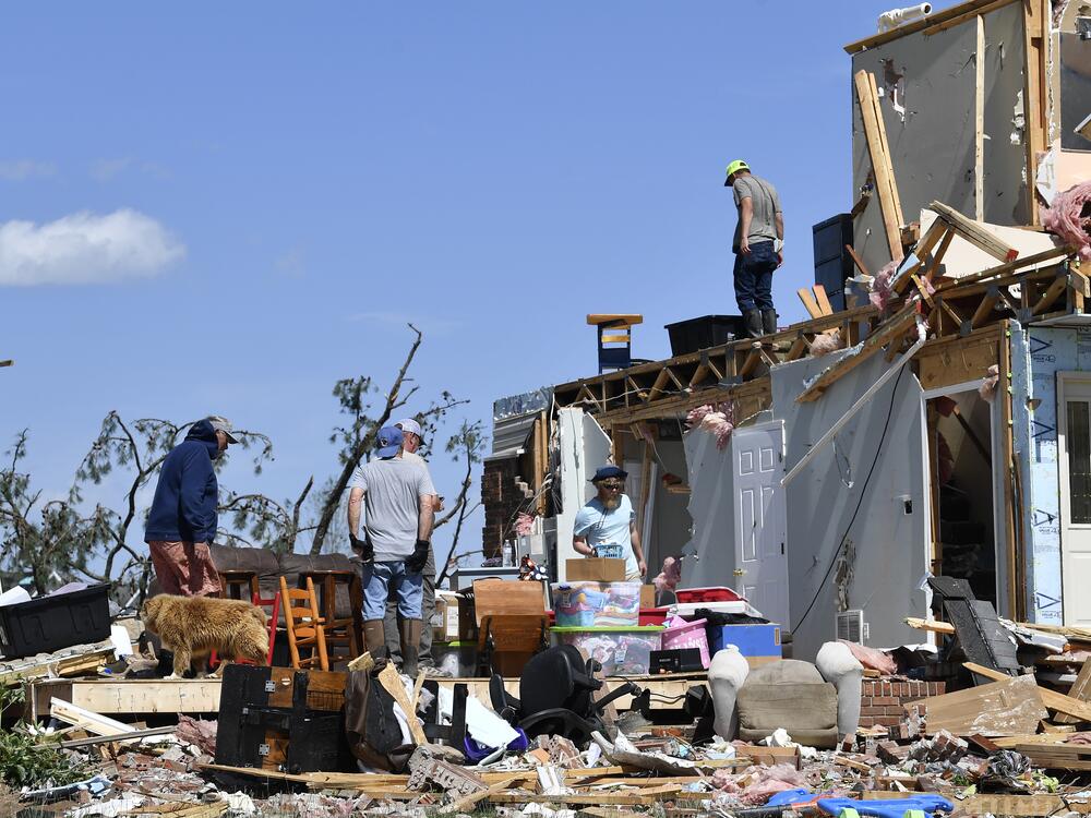 Family members cull through the debris of their home that was destroyed by a severe storm in London, Ky., on Saturday.
