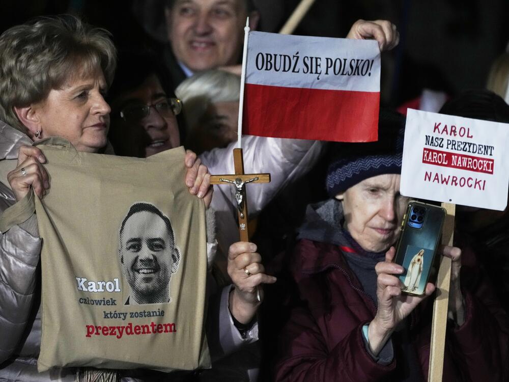Supporters of conservative presidential candidate Karol Nawrocki hold up signs as they rally in Warsaw, Poland, Tuesday, May 13, 2025. The writing reads: Karol, the man who will become president, Wake up, Poland! and Our president Karol Nawrocki.