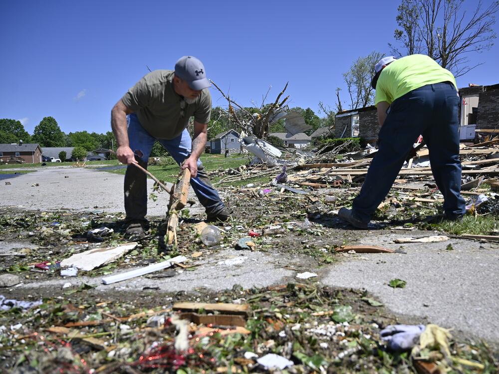 Volunteers help clear debris from a road following severe storms last night in London, Ky., on Saturday.