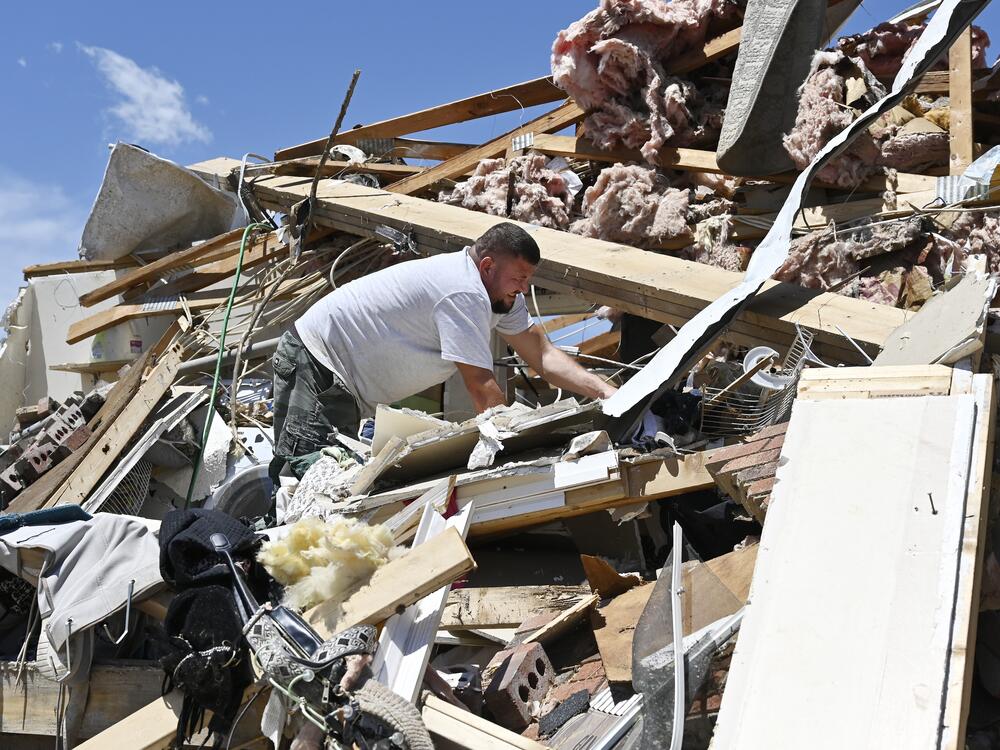 Anthony Broughton digs through the debris of his destroyed home following a severe storm in London, Ky., on Saturday.
