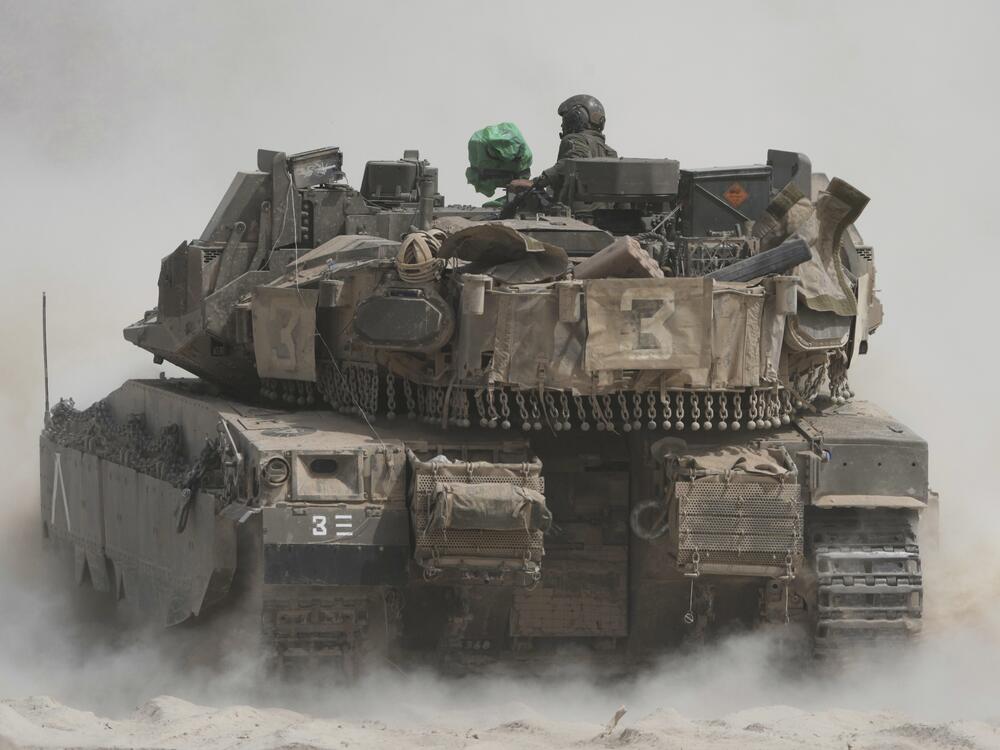 Israeli soldiers move tanks around staging area near the border with the Gaza Strip, in southern Israel, Sunday, May 18, 2025.