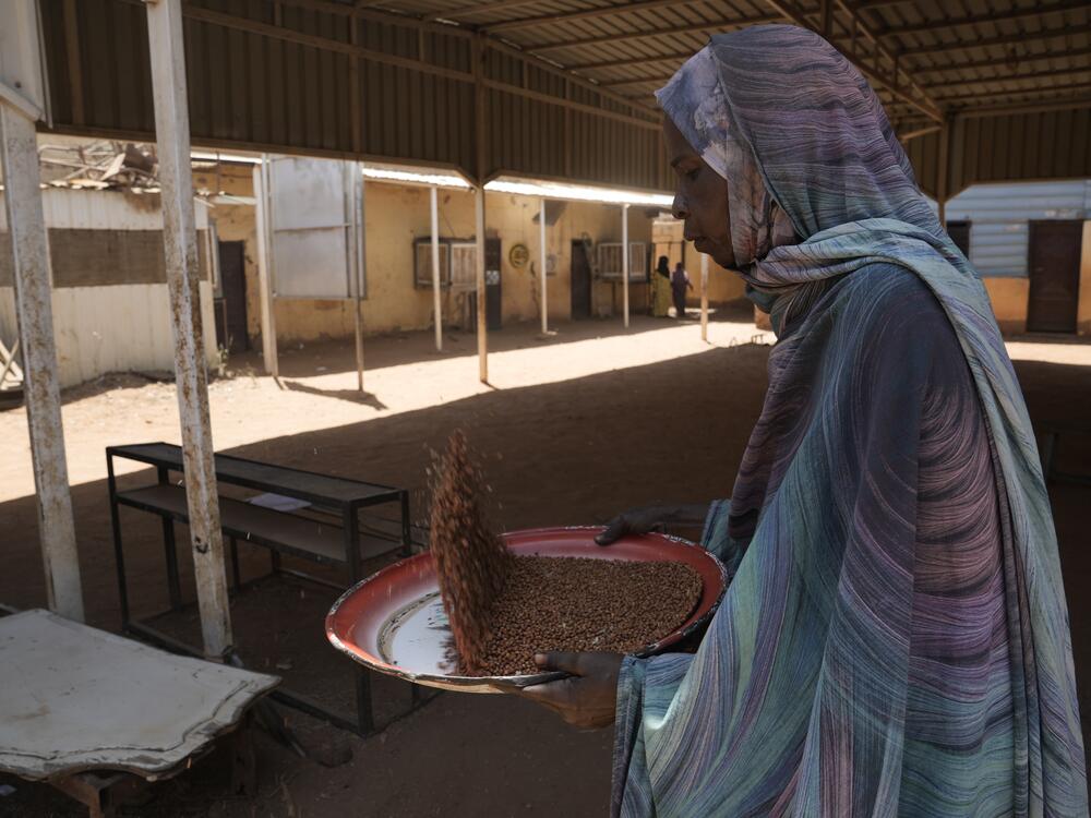 A volunteer at a community kitchen in Khartoum prepares food to be distributed to those in need.