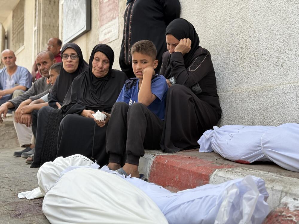 Members of the Nasser family sit with the bodies of their relatives at the morgue of Shifa hospital in Gaza City following an airstrike that killed 20 Palestinians according to Gaza health officials, on May 18, 2025.