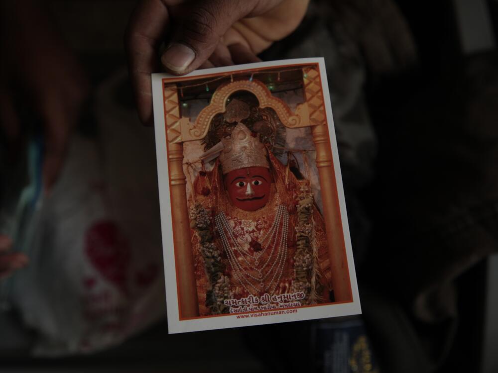 A man holds an image of the beloved Hindu monkey god Hanuman, given to him by an administrator at the Chamatkarik Shree Hanumanji Mandir in the old city of Ahmedabad in western India, on March 19.