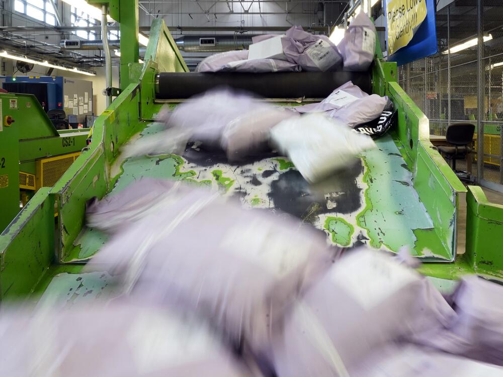 Parcels slide down a ramp after being scanned at the U.S. Customs and Border Protection overseas mail inspection facility at Chicago's O'Hare International Airport on Feb. 23, 2024.