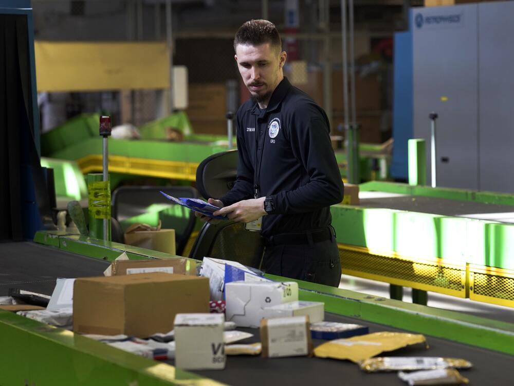 A U.S. Customs and Border Protection technician examines overseas parcels after they were scanned at the agency's overseas mail inspection facility at Chicago's O'Hare International Airport on Feb. 23, 2024.