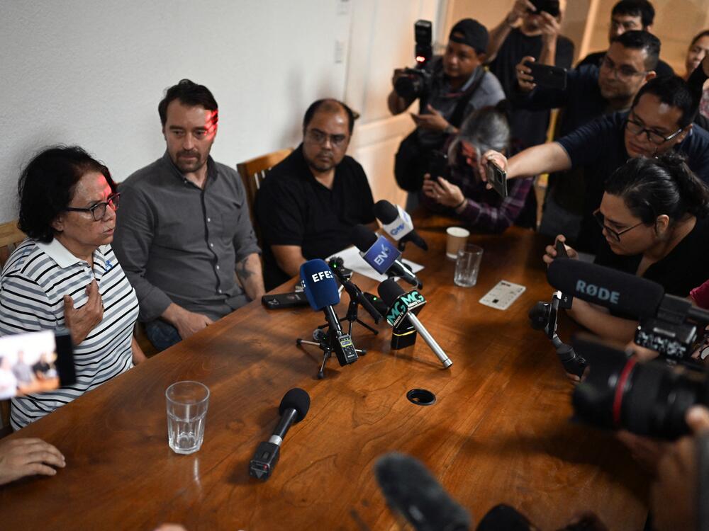 Eleonora Alfaro (L), mother of lawyer Ruth Lopez of the human rights group Cristosal, speaks next to Noah Bullock (C), executive director of Cristosal, and Louis Benavides (R), partner of Lopez, during a press conference in El Salvador.