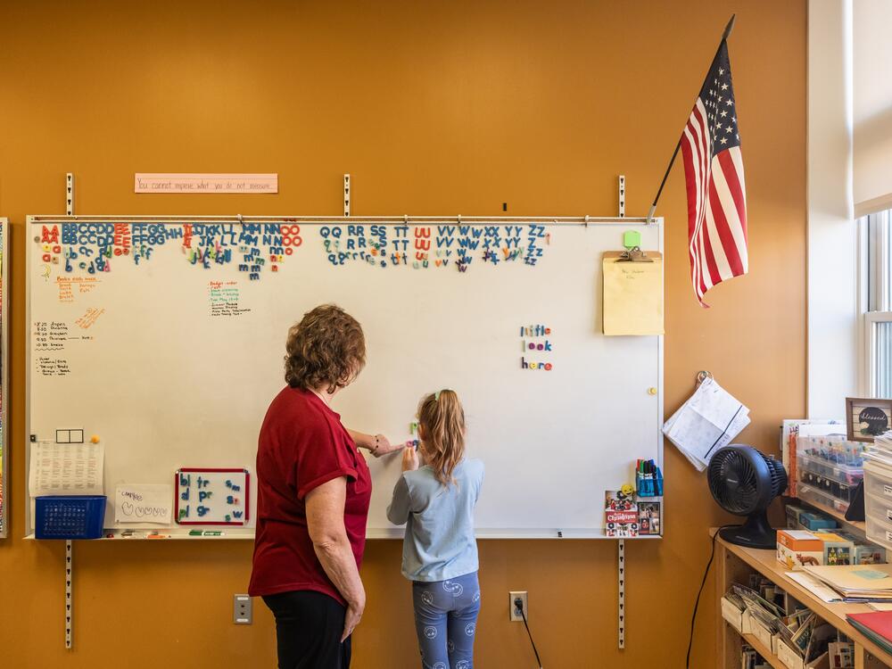 Reading interventionist Roxanne Davis works with a first grader on forming words at Mill Stream Elementary School.