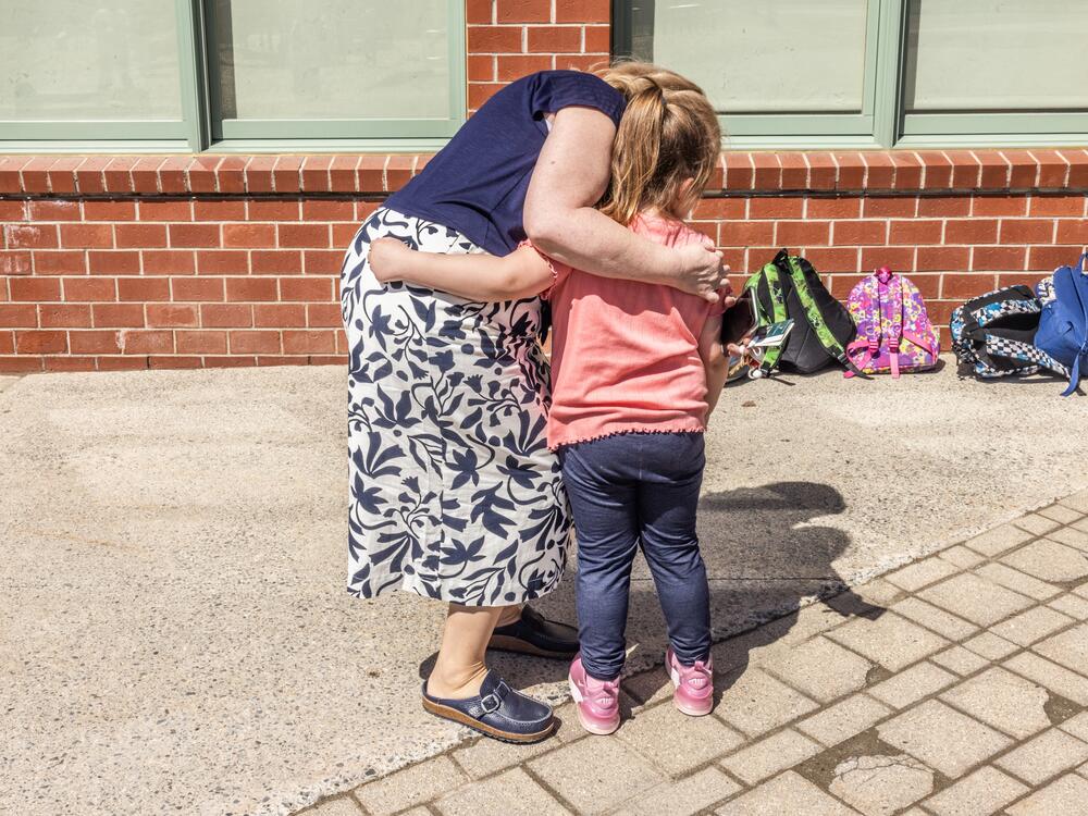 Barbara Welch hugs a student goodbye at the end of the day.