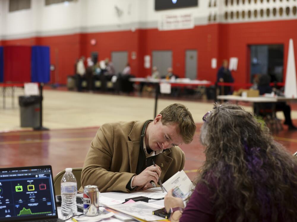 A voter registers to vote in Derry, N.H., on March 11. New Hampshire's March elections were the first test of the state's new proof-of-citizenship law.