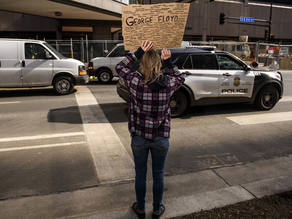 A Minneapolis Police cruiser drives by as people demonstrate outside the Hennepin County Government Center on March 9, 2021 in Minneapolis.