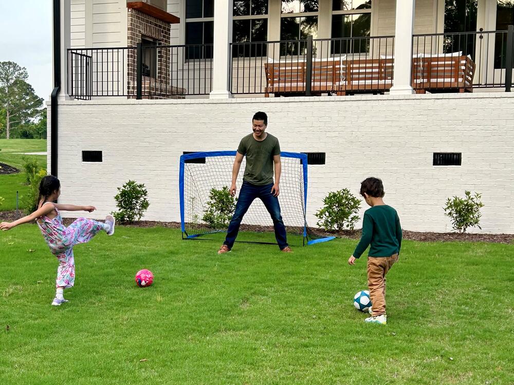 Jim Xiao paid an agent a flat $10,000 fee to help him buy a home in Evans, Ga., last year. Here, Xiao and his children play soccer at their new home.