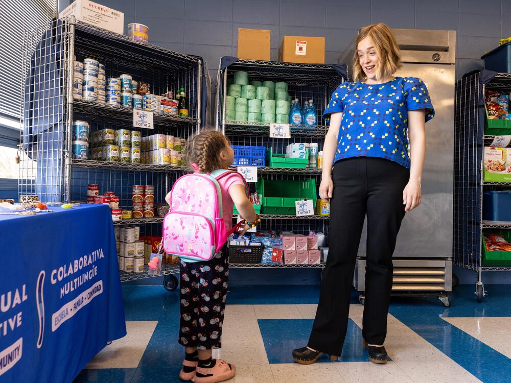 Megan Mainzer, the McKinney-Vento liaison for Middletown Public Schools in Rhode Island, speaks with a young girl at the Island Oasis, a food and clothing pantry that's managed, in part, with federal grant money.
