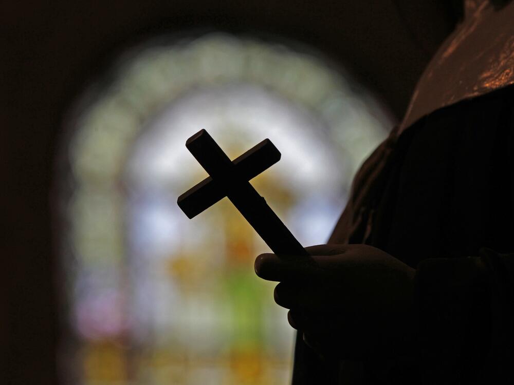 FILE - A silhouette of a crucifix and a stained glass window is seen inside a Catholic Church in New Orleans, Dec. 1, 2012.