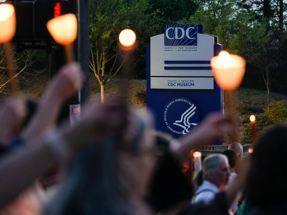 People participate in a candlelight vigil in front of the main offices of the Centers for Disease Control in Atlanta on March 28, days before thousands of CDC employees were laid off.