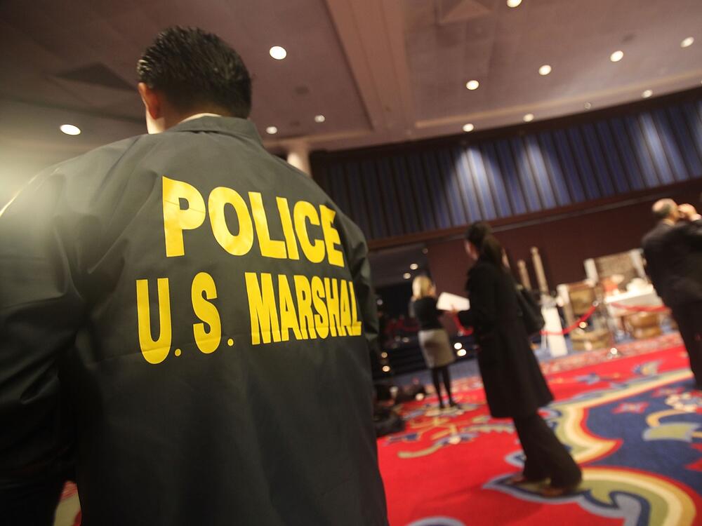 A U.S. Marshal looks on an auction in 2009 in New York City.